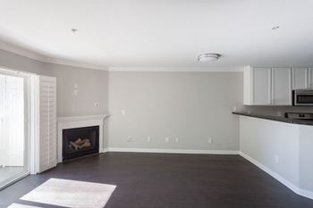 A living room with a fireplace and a kitchen